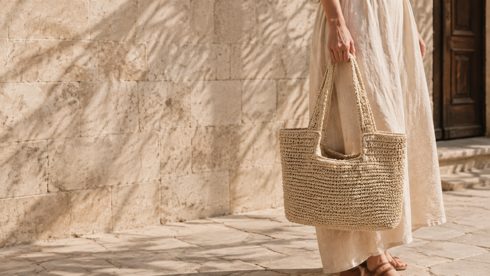 Our natural woven shoulder tote styled with linen in a sunlit courtyard; AI styling scene